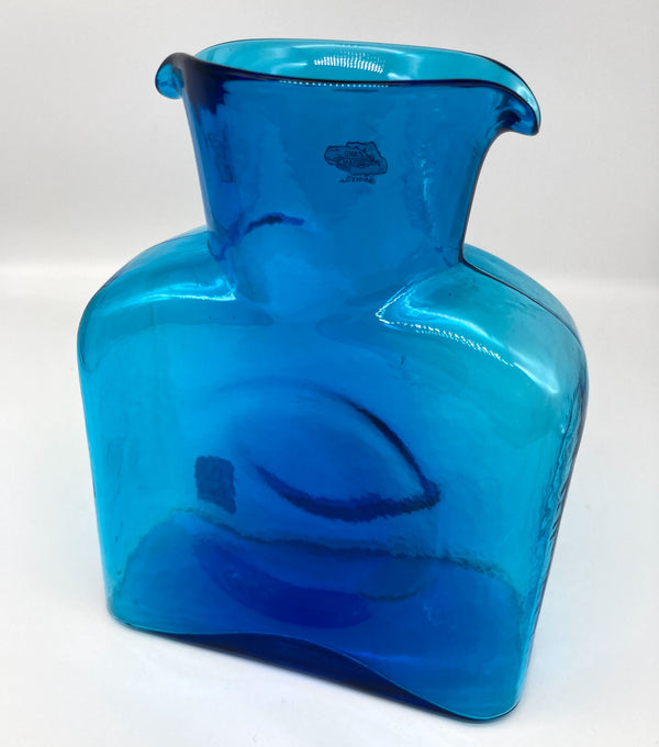 A turquoise glass water bottle.