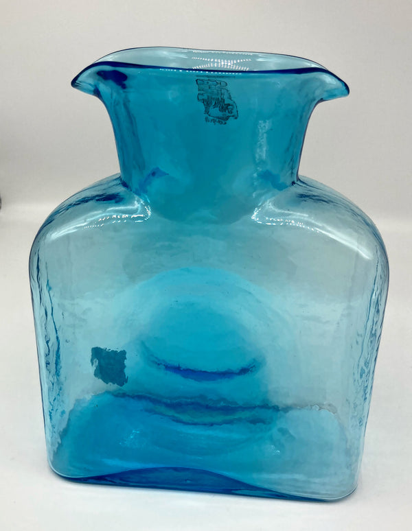 An ice blue glass water bottle.
