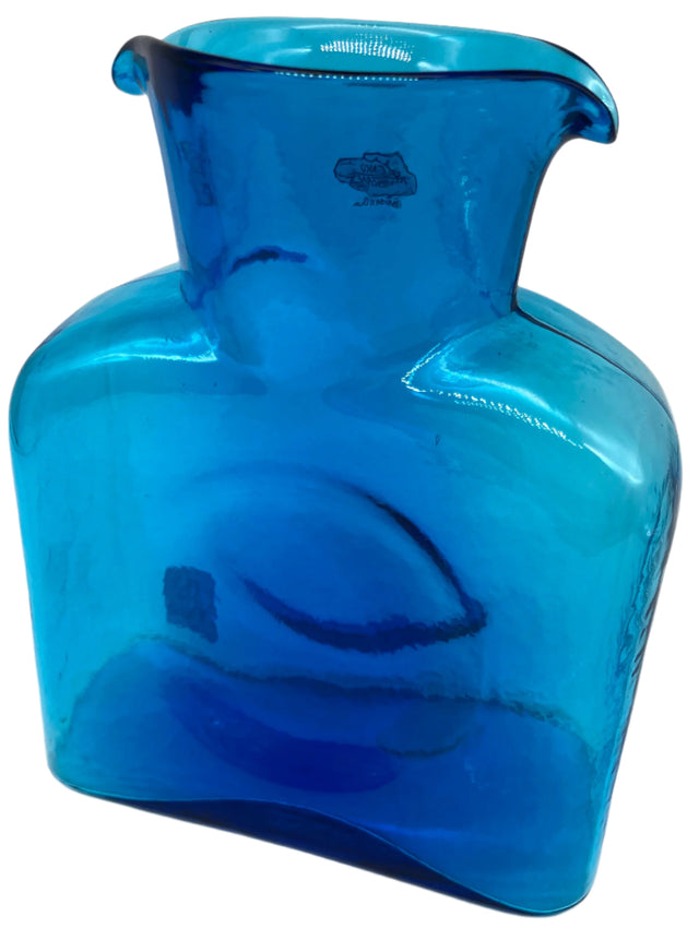 A turquoise glass water bottle.