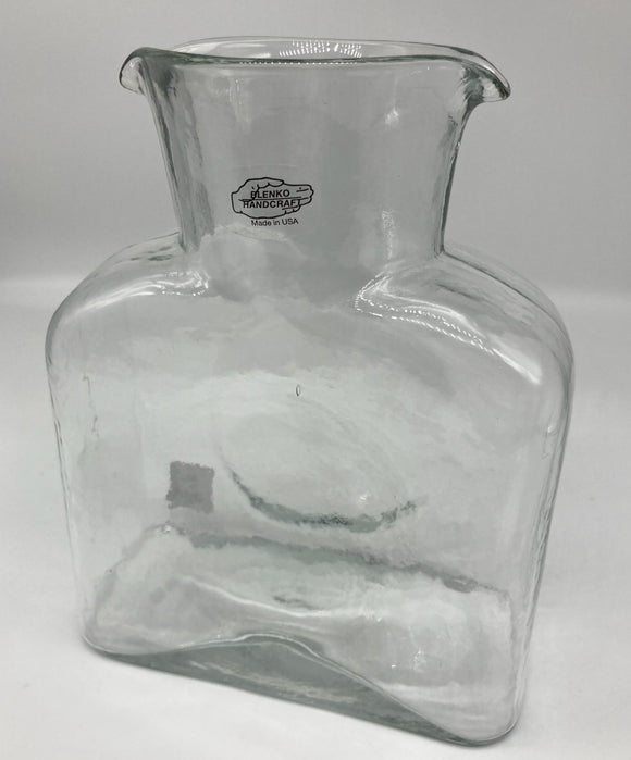 A crystal clear glass water bottle.