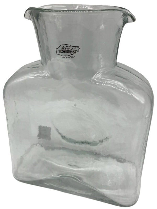 A crystal clear glass water bottle.