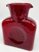 A red ruby glass water bottle.