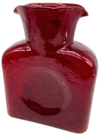 A red ruby glass water bottle.