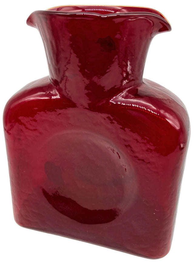A red ruby glass water bottle.